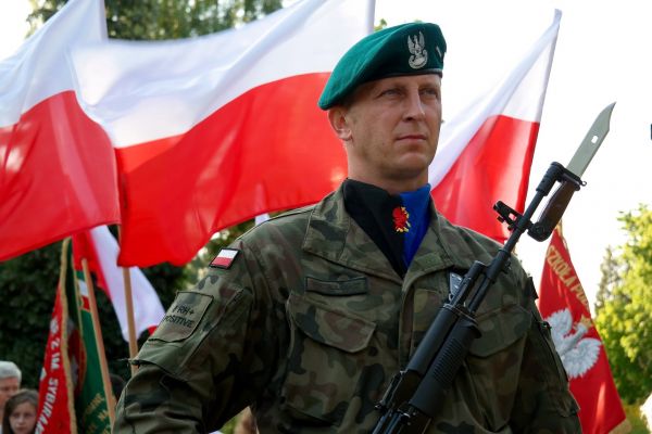 Polski żołnierz na tle flagi narodowej