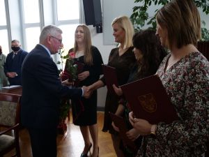 Przewodniczący Rady Powiatu Mławskiego wręcza kwiaty dla awansowaych nauczycieli